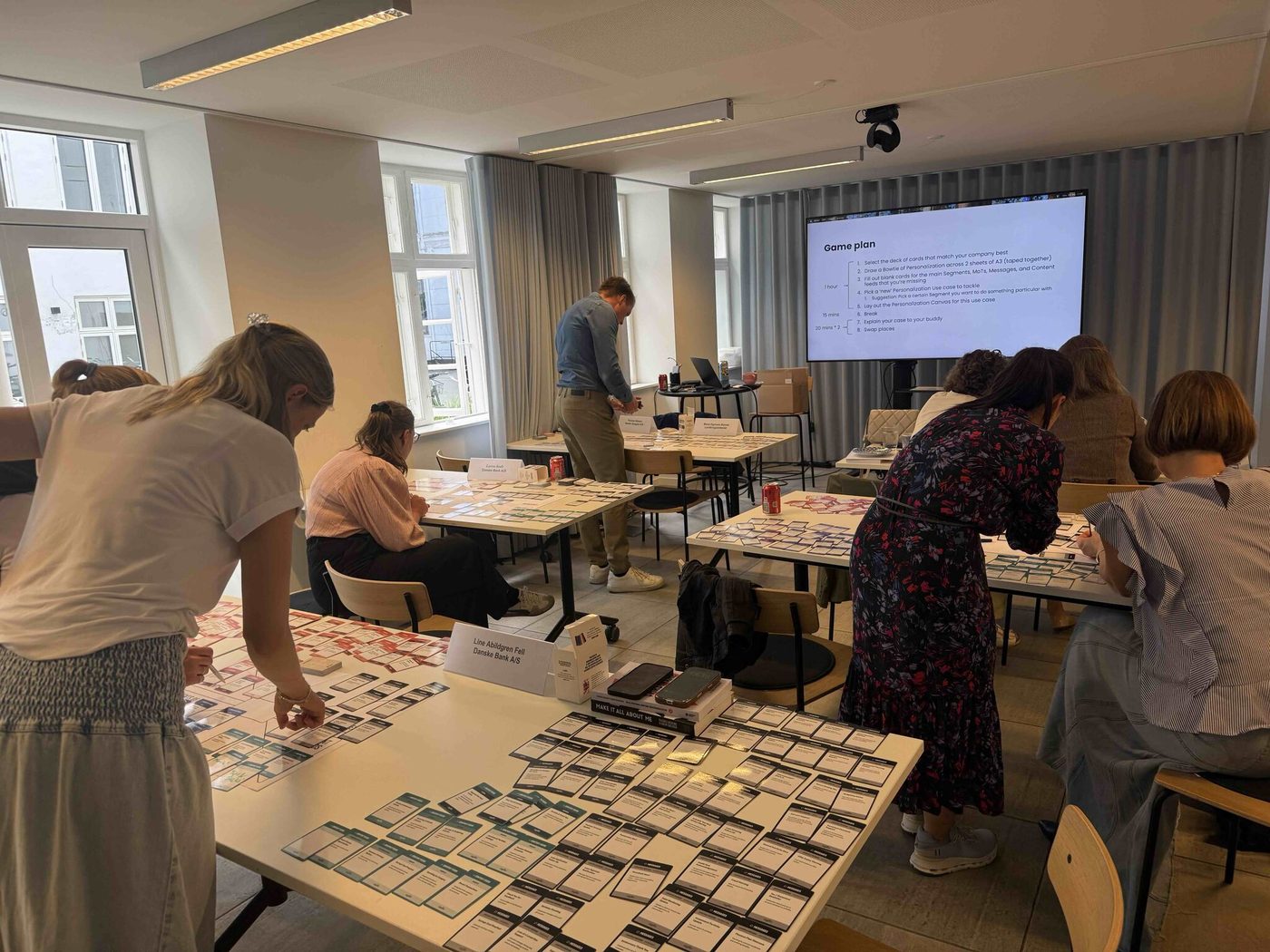 Deltagere fra Danske Bank i gang med at l&aelig;gge Personalisation Cards p&aring; bordet under et tidligere hold